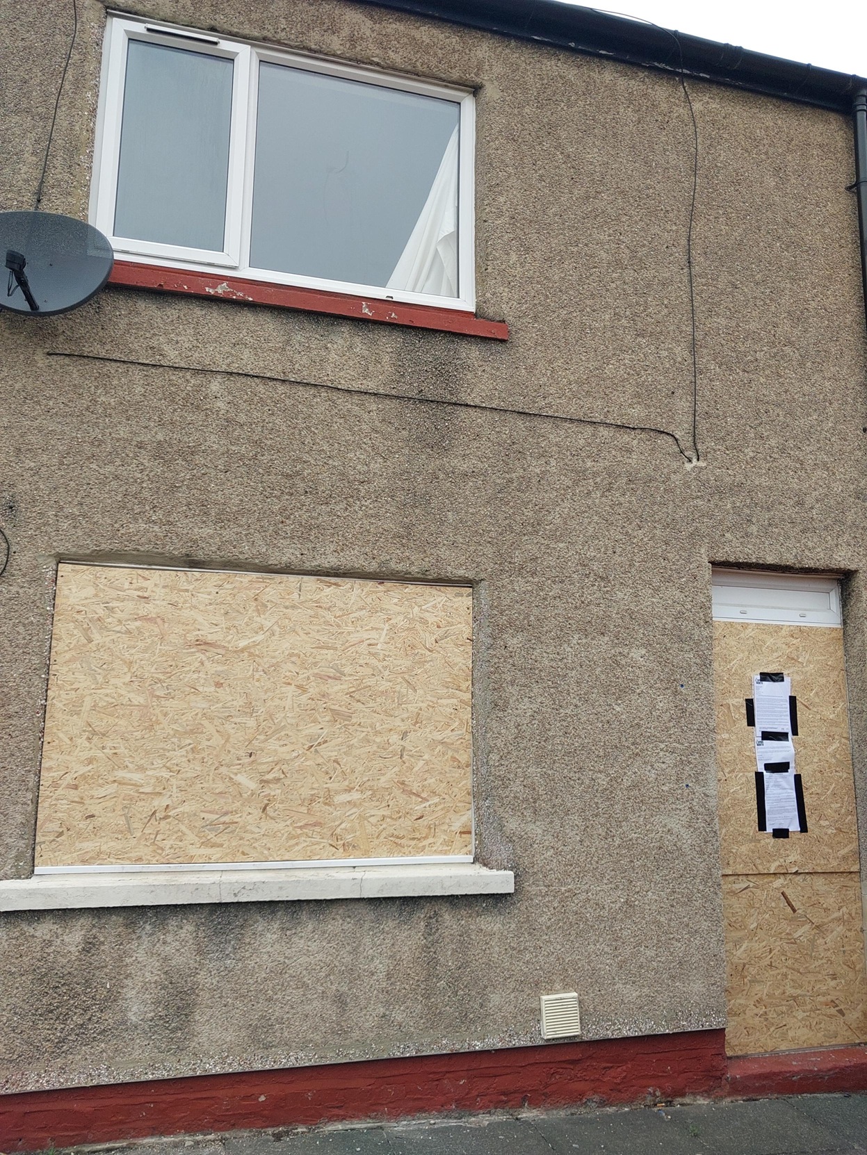 The house with boarded up window and door