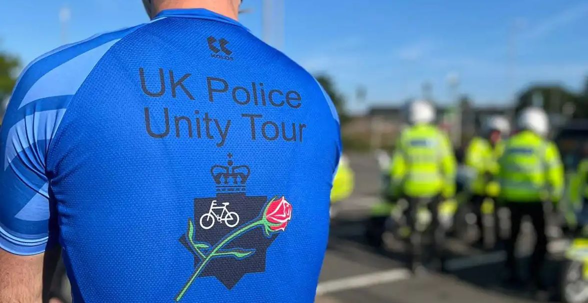 The back of a rider's blue shirt which says 'UK Police Unity Tour'