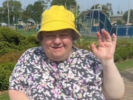A photograph of Angela waving