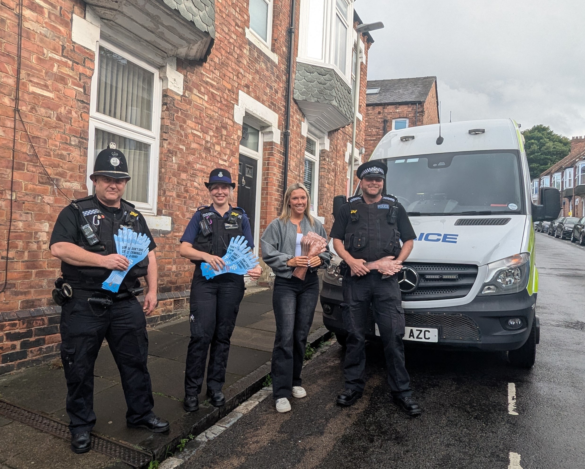 Four members of the Durham City Neighbouhood Policing Team in front of a police van in a terraced street