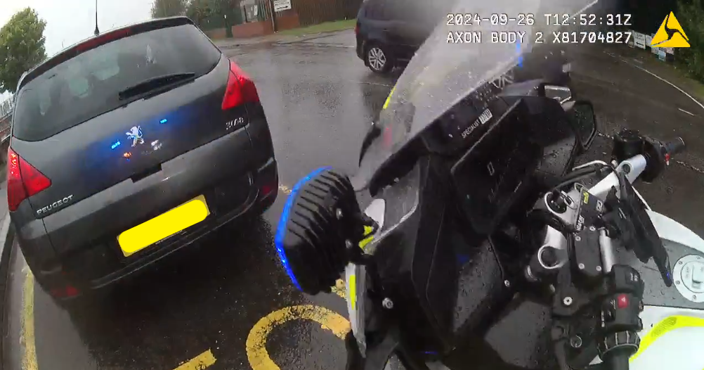 A police motorcycle pulls over a car
