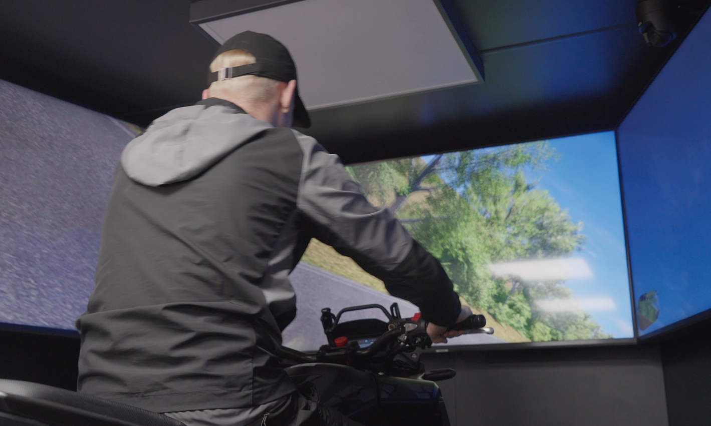 A teenage boy riding the bike simulator
